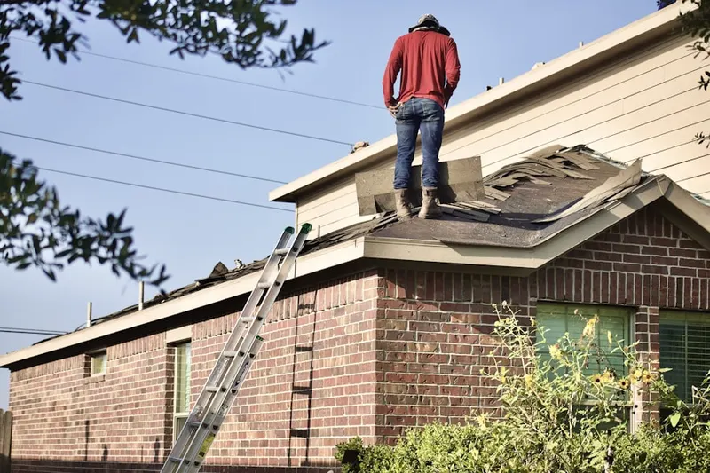 Professional roofer working on a residential roof in Arcanum